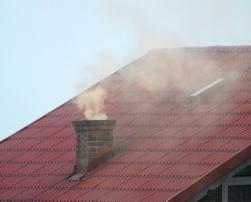 Smoke coming from house´s chimney, air pollution