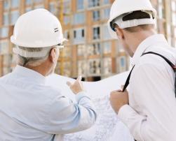 Two men controlling building design on construction site
